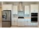 Modern kitchen with white cabinets, stainless steel appliances, and quartz countertops at 8592 Hempstead Way, Mount Dora, FL 32757