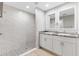 Bathroom featuring dual vanities, sleek mirrors, and tiled shower with modern fixtures at 91 Locust Loop, Ocala, FL 34472