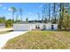 Charming single-story home featuring a two-car garage and a well-manicured lawn on a sunny day at 91 Locust Loop, Ocala, FL 34472