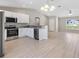 Open concept kitchen with stainless steel appliances and bar seating flows into living area at 91 Locust Loop, Ocala, FL 34472