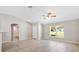 Spacious, well-lit living area with stylish wood-look flooring, a view into a bathroom, and a bright window at 91 Locust Loop, Ocala, FL 34472