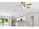 Bright living area with wood-look flooring, seamlessly connecting to a modern kitchen with stainless steel appliances at 91 Locust Loop, Ocala, FL 34472