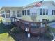 Exterior shot of the home with a wooden ramp, enclosed porch, and neatly landscaped yard at 975 Cr 461, Lake Panasoffkee, FL 33538