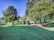 Landscaped backyard with lush green grass and mature trees at 16914 Se 96Th Chapelwood Cir, The Villages, FL 32162