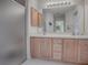 Bathroom features double sinks, light wood cabinets, and a shower at 16914 Se 96Th Chapelwood Cir, The Villages, FL 32162