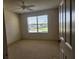 Standard bedroom featuring neutral walls, patterned carpeting, and a window offering natural light at 16914 Se 96Th Chapelwood Cir, The Villages, FL 32162