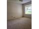 Standard bedroom featuring neutral walls, patterned carpeting, and a window offering natural light at 16914 Se 96Th Chapelwood Cir, The Villages, FL 32162