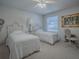 Bright bedroom with two beds, adorned with decorative art and a ceiling fan for added comfort at 16914 Se 96Th Chapelwood Cir, The Villages, FL 32162