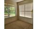 Well-lit bedroom featuring plush carpeting and large windows with serene views of the surrounding greenery at 16914 Se 96Th Chapelwood Cir, The Villages, FL 32162