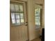 View of the home's entry door with a window, showing light and outdoor views through the blinds at 16914 Se 96Th Chapelwood Cir, The Villages, FL 32162