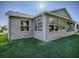Exterior view of house with a large sunroom and well-maintained lawn at 16914 Se 96Th Chapelwood Cir, The Villages, FL 32162