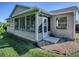 Tan house exterior with a screened porch and landscaping at 16914 Se 96Th Chapelwood Cir, The Villages, FL 32162