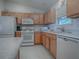 Kitchen features light wood cabinets, white appliances, and a granite countertop at 16914 Se 96Th Chapelwood Cir, The Villages, FL 32162