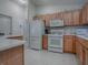Functional kitchen featuring oak cabinets, white appliances, and tiled floors, ready for your culinary creations at 16914 Se 96Th Chapelwood Cir, The Villages, FL 32162