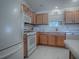 Kitchen features light wood cabinets, white appliances, and a granite countertop at 16914 Se 96Th Chapelwood Cir, The Villages, FL 32162