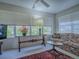 Sunlit living room featuring floral sofa and large windows at 16914 Se 96Th Chapelwood Cir, The Villages, FL 32162