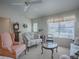 Living room features a floral couch and a glass-top coffee table at 16914 Se 96Th Chapelwood Cir, The Villages, FL 32162