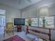 Comfortable living room features a large window, a floral arrangement, and a ceiling fan at 16914 Se 96Th Chapelwood Cir, The Villages, FL 32162