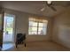 A cozy living room with a ceiling fan, window with outdoor view, and walker; bathed in natural light at 16914 Se 96Th Chapelwood Cir, The Villages, FL 32162