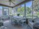 Charming sunroom with ample seating and large windows overlooking a well-manicured backyard at 16914 Se 96Th Chapelwood Cir, The Villages, FL 32162