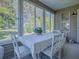 Sunroom features a table and chairs with a view of the backyard at 16914 Se 96Th Chapelwood Cir, The Villages, FL 32162