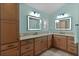 Bathroom boasts double vanity with granite countertop and lighted mirrors at 3113 Sweetgum St, The Villages, FL 32163