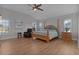 Spacious bedroom with wood flooring, ceiling fan, and large windows at 3113 Sweetgum St, The Villages, FL 32163