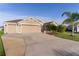 Tan house with three-car garage and palm trees at 3113 Sweetgum St, The Villages, FL 32163