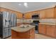 Island kitchen with granite countertops and wood cabinets at 3113 Sweetgum St, The Villages, FL 32163