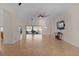 Spacious living room with tile floors, large TV, and access to pool at 3113 Sweetgum St, The Villages, FL 32163