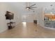 Spacious living room with tile floors, a large TV, and access to the kitchen at 3113 Sweetgum St, The Villages, FL 32163