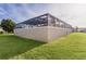 Screened pool enclosure with a large grassy area at 3113 Sweetgum St, The Villages, FL 32163