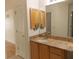 Bathroom featuring granite countertop, wooden cabinets, and a mirror at 3213 Archer Ave, The Villages, FL 32162