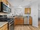 Stainless steel appliances, light wood cabinets, and a view into the connected dining room at 3213 Archer Ave, The Villages, FL 32162