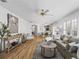 Open-concept living room with hardwood floors, cozy sofa, and access to the kitchen and dining area at 3213 Archer Ave, The Villages, FL 32162