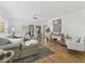 Bright living room with hardwood floors, fan, light gray sofa, and view to the outside through sliding glass doors at 3213 Archer Ave, The Villages, FL 32162