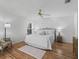 A well-lit main bedroom boasts beautiful wood floors, a ceiling fan, and a cozy area rug at 3213 Archer Ave, The Villages, FL 32162