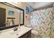 Charming bathroom with decorative shower curtain and mirror at 505 W Catawba St, Fruitland Park, FL 34731
