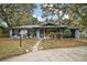 Ranch style home with red door, landscaping, and a paved driveway at 505 W Catawba St, Fruitland Park, FL 34731
