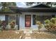 Red front door, stone walkway, and mature landscaping at 505 W Catawba St, Fruitland Park, FL 34731
