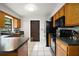 Well-equipped kitchen with black appliances, wooden cabinets and a breakfast bar at 505 W Catawba St, Fruitland Park, FL 34731