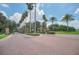 Grand entrance to the community featuring lush landscaping and stately palm trees at 6607 Crestmont Glen, Windermere, FL 34786