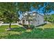 Two-story home with a manicured front lawn and mature trees, offering curb appeal and charm at 9249 Ivywood St, Clermont, FL 34711