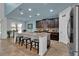 Modern kitchen showcasing a large island with seating, dark cabinetry, and stainless steel appliances at 9249 Ivywood St, Clermont, FL 34711