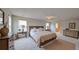 An expansive bedroom with neutral walls and floors and featuring lamps and wooden furniture at 1710 Summer Rose Dr, Mount Dora, FL 32757
