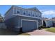 Two-story house with gray siding, a brick driveway, and landscaping at 1710 Summer Rose Dr, Mount Dora, FL 32757
