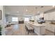 Modern open kitchen with pendant lights and white cabinets flows into the living area at 1710 Summer Rose Dr, Mount Dora, FL 32757