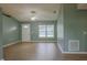 Inviting living room with hardwood floors, ceiling fan, and ample natural light from the large front windows at 1761 12Th St, Orange City, FL 32763