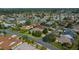 Aerial view of a single-story home showcasing mature trees, a well-manicured lawn, and neighborhood setting at 1828 Feliciana Ter, The Villages, FL 32162