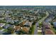 Aerial view of a single-story home showcasing mature trees, a well-manicured lawn, and neighborhood setting at 1828 Feliciana Ter, The Villages, FL 32162